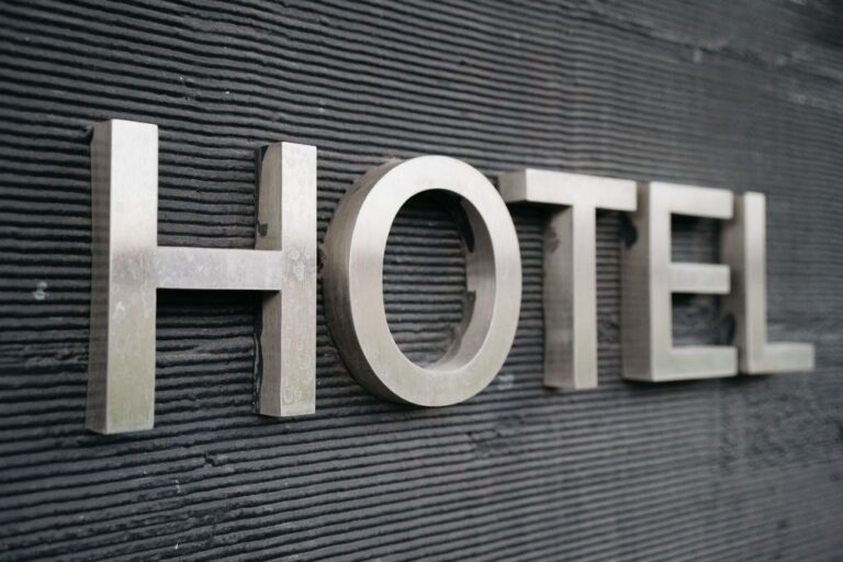 Brushed steel 3D letters mounted on a textured facade wall