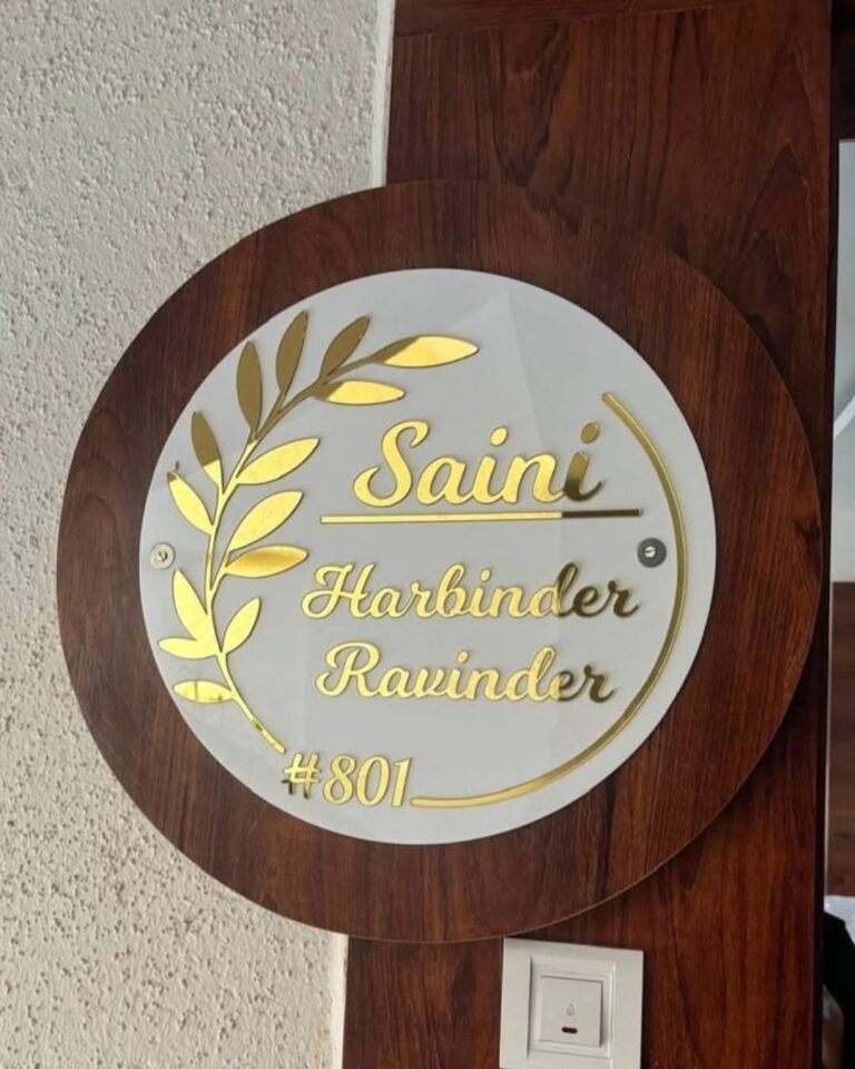 Round acrylic name plate with gold leaf design on wood
