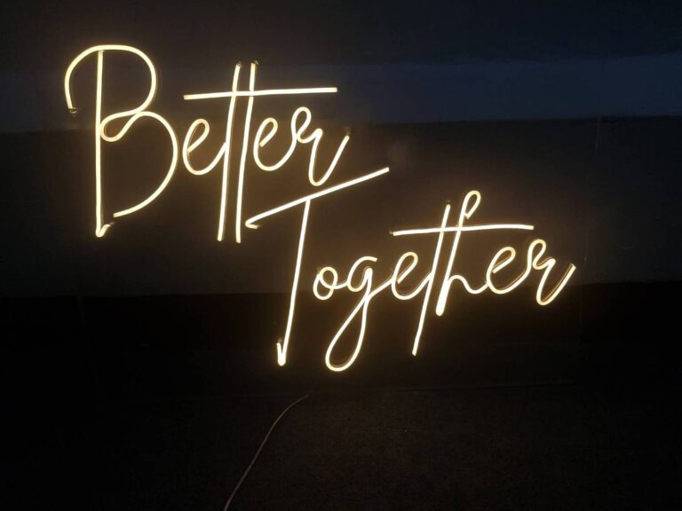 Warm white script neon sign reading Better Together